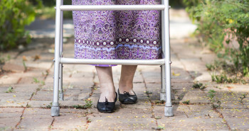 mulher idosa com andador se prevenindo de quedas